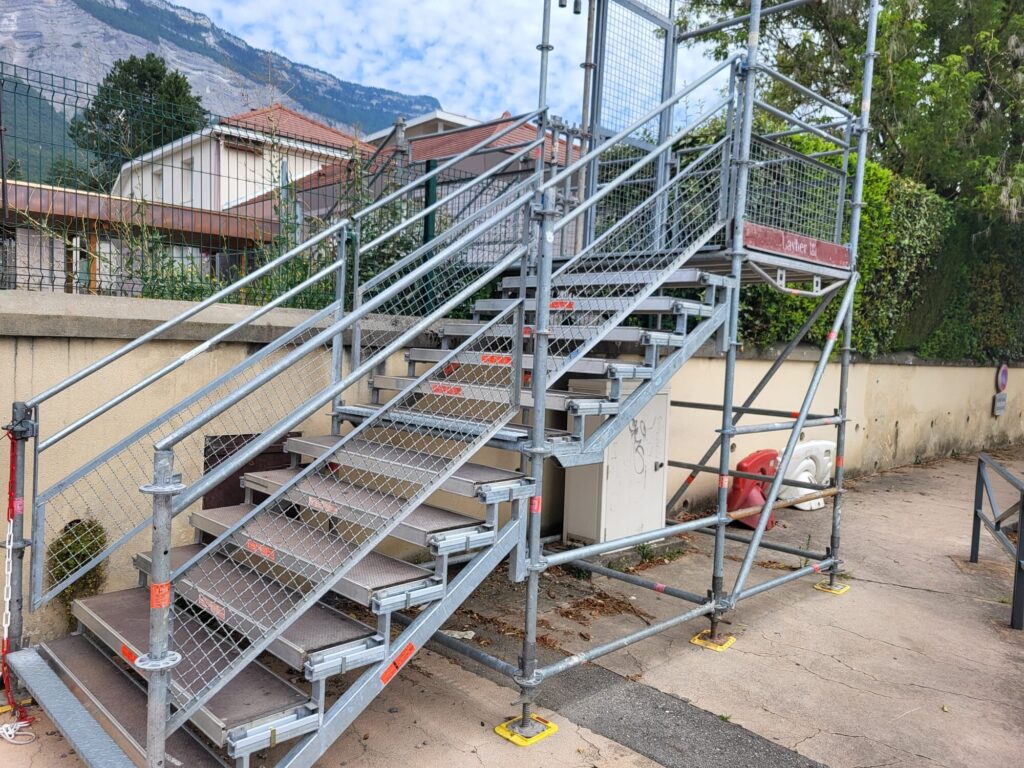 Volées d'escalier d'une tour d'accès en échafaudage, marches antidérapantes et garde-corps des deux côtés